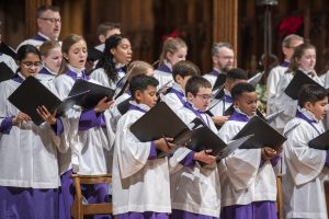 Choir singing with Christmas flower decorations in the background