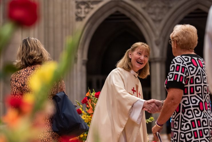 Clergy greeting worshippers coming in for service in the Nave of the Cathedral