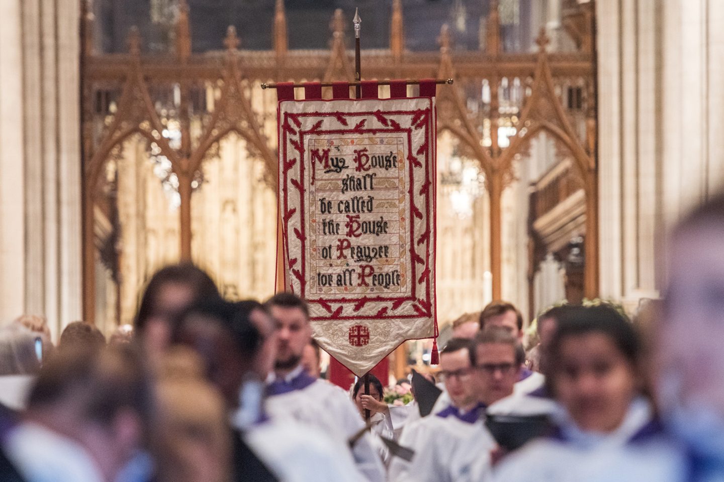 Choir processing and carrying a banner that reads, "My House shall be called the House of Prayer for all People," in the Nave of Washington National Cathedral