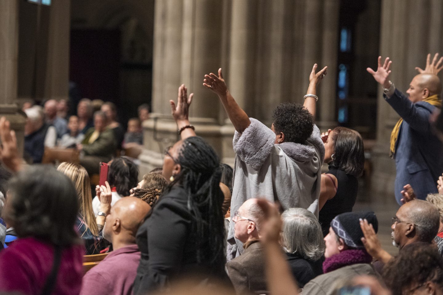 Worshippers in the Cathedral Nave, some waving hands