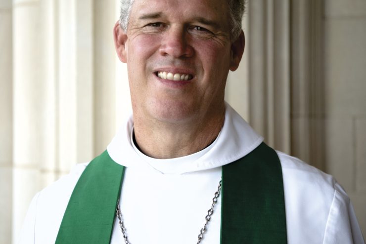 Headshot of Cathedral Dean Randy Hollerith, smiling and wearing priestly vestments