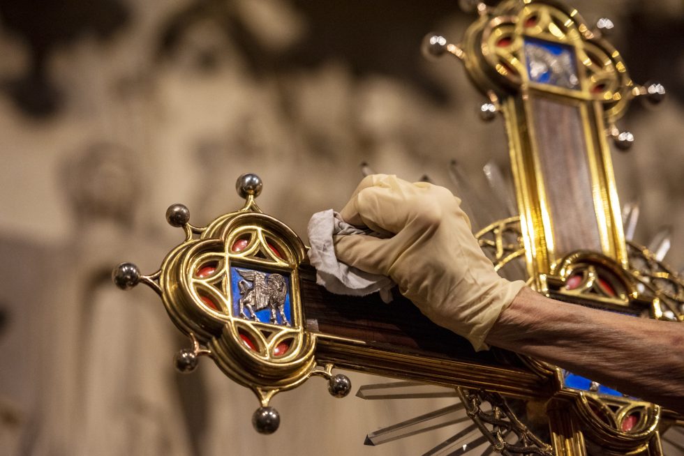 Hand polishing silver and gold accents on cross