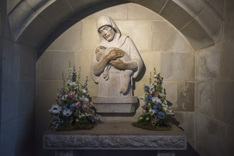 Reredos carving framed by flower arrangements in Cathedral's Good Shepherd chapel