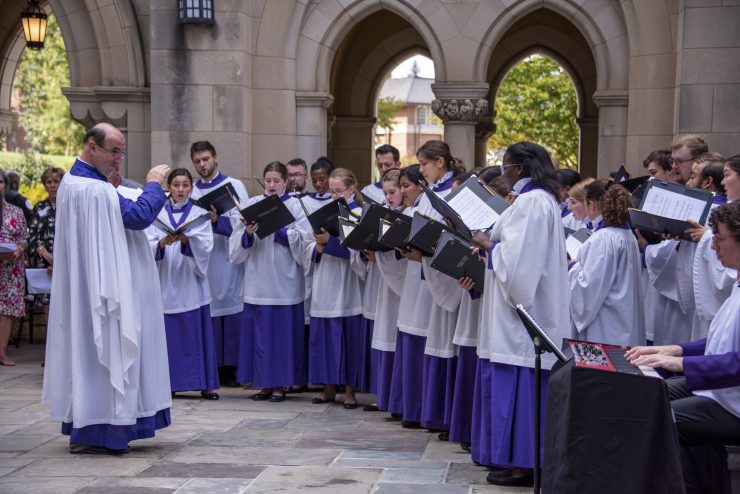 Conductor and choir singing in the Cathedral's Garth