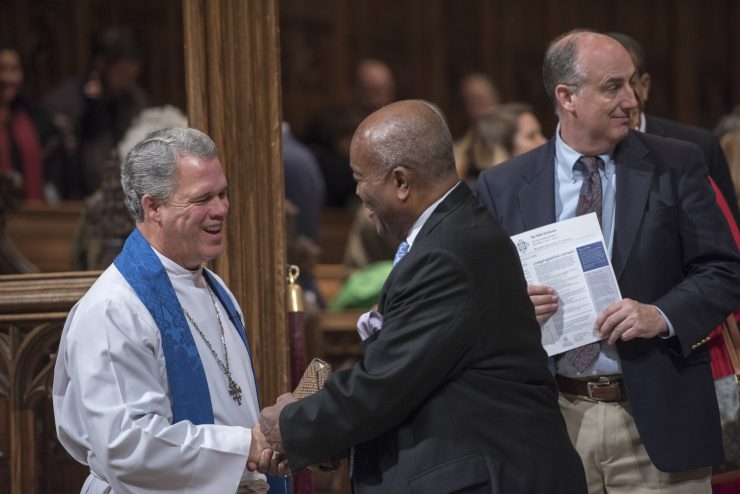 Dean of the Cathedral greeting worshippers coming in for service