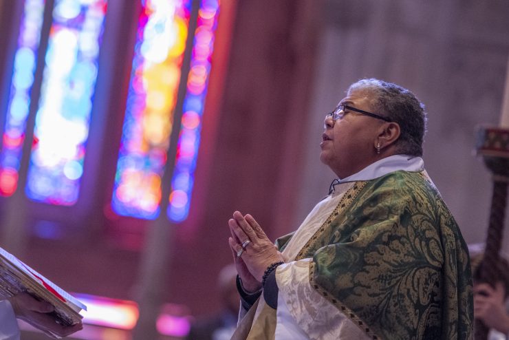 Clergy singing with hands folded in prayer